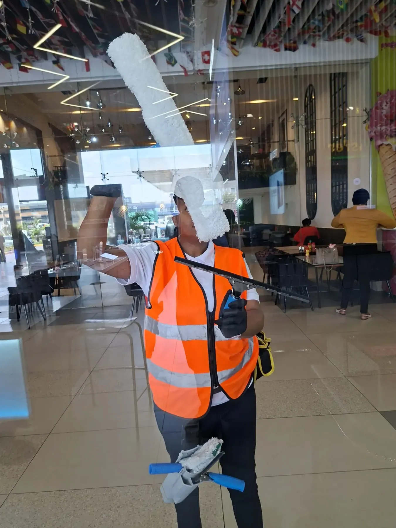 NUVORA cleaner using professional tools on a commercial glass entrance